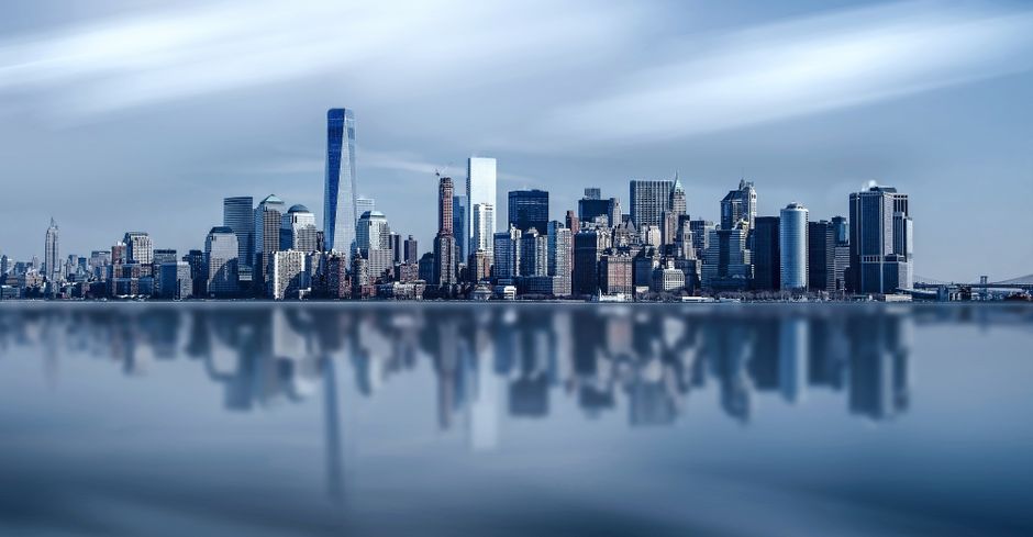 A financial district skyline reflects the scale of the public markets absorbing new equity supply.