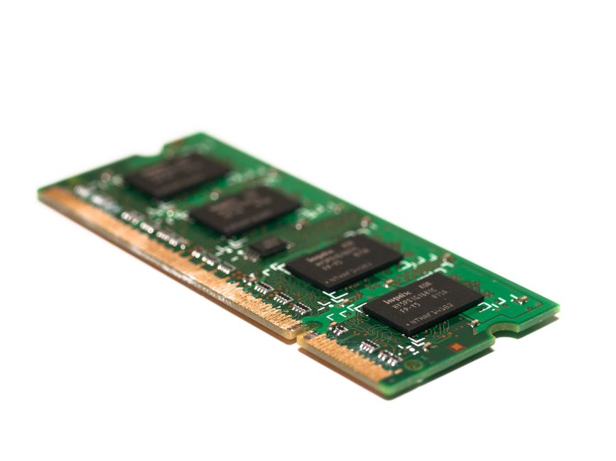 Close-up of a green electronic memory module against a white background, showcasing modern technology.