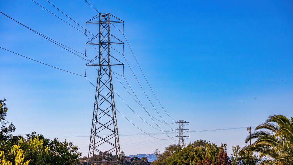 High-voltage transmission towers representing infrastructure investment and the capital required for public-market growth