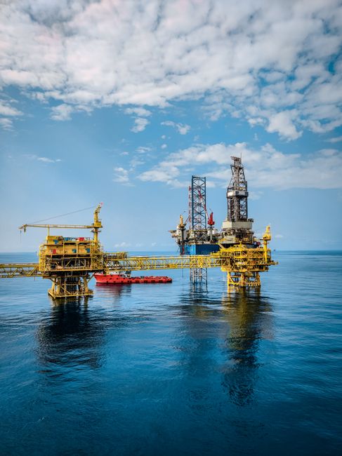 Offshore oil rig platform standing in calm blue sea under a clear sky