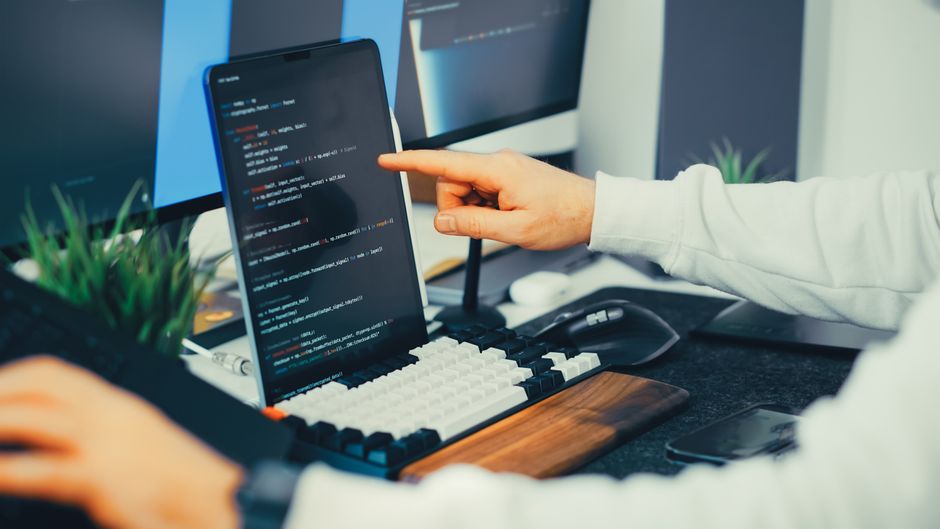 A programmer works on cloud software code in an office setting.