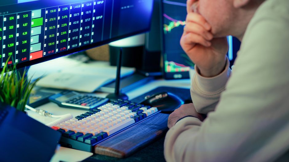 Trader reviewing equity and bond-market data during a session of sector rotation.