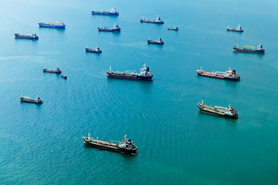 Cargo ships wait offshore as markets reassess Strait of Hormuz shipping risk.