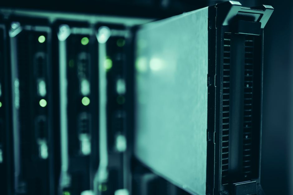 Rows of illuminated server racks in a large data center facility with blue indicator lights