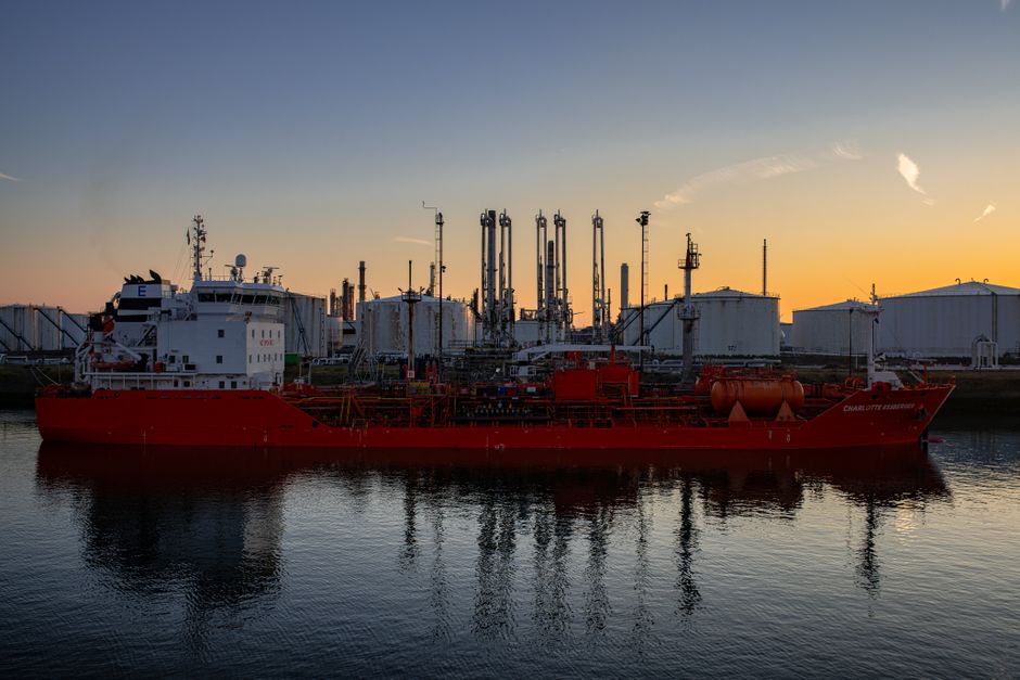 An industrial ship sits beside refinery infrastructure as Gulf tensions push energy prices higher.